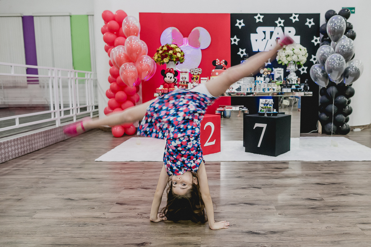 plantando bananeira na frente da mesa do bolo