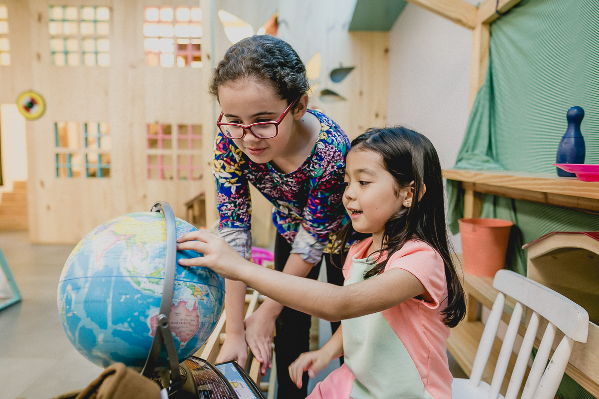 carol se divertindo com o globo do mundo dentro do espaço cade bebe