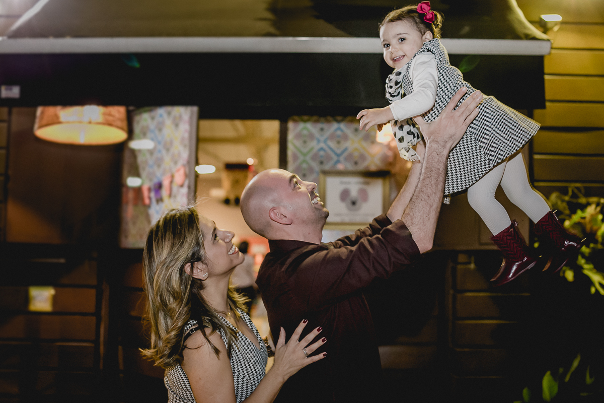 Papai e mamãe brincando com a Alice na fachada do Buffet Miniland  - Tatuapé - SP