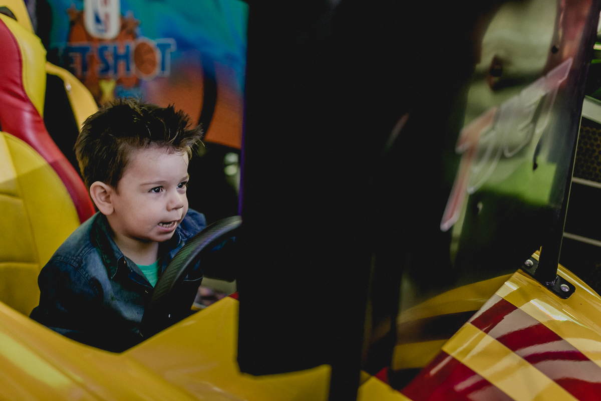 Lucas brincando de corrida no jogo de carro no Espaço Diversão e Arte - Zona Norte - SP