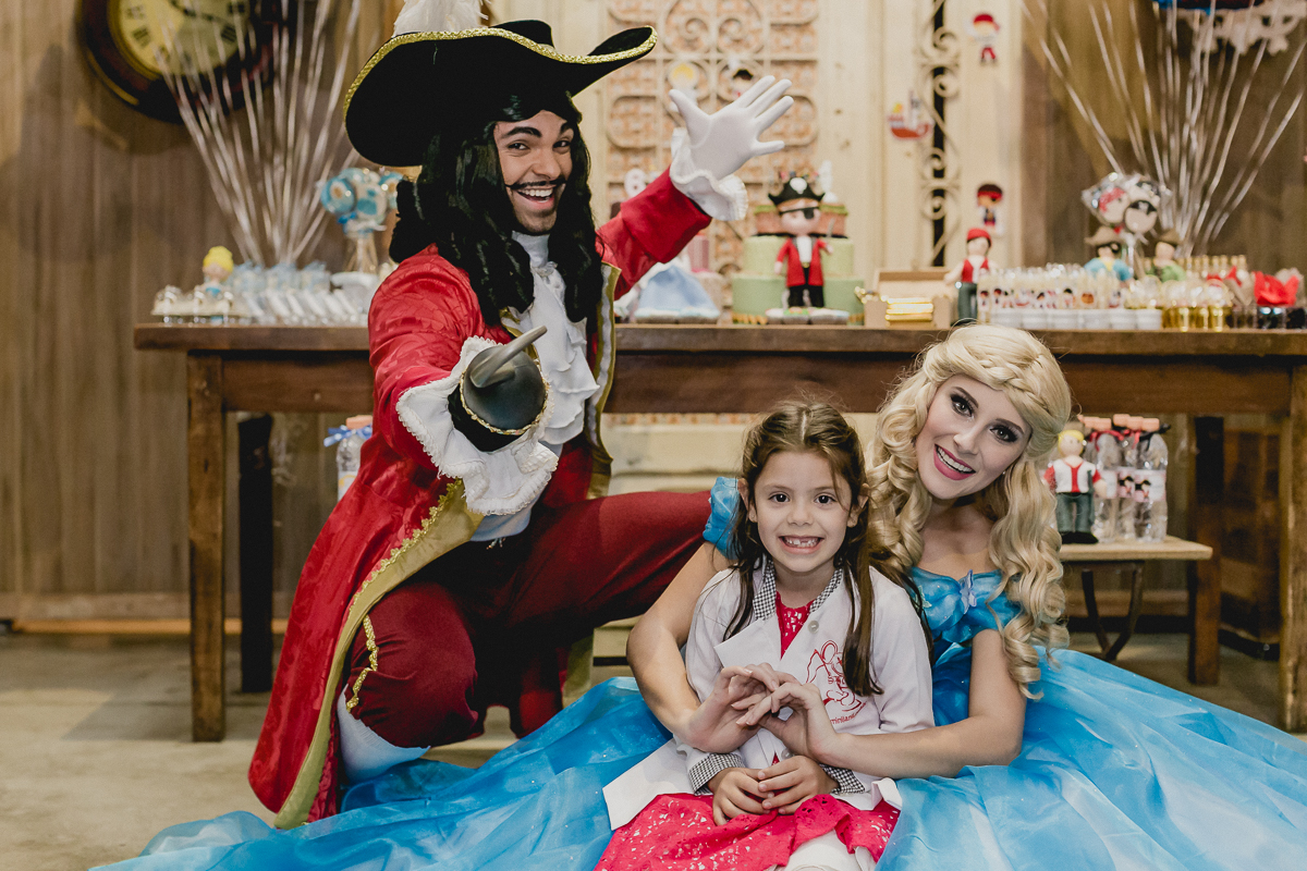 Bruna com o pirata e a cinderela na mesa do bolo