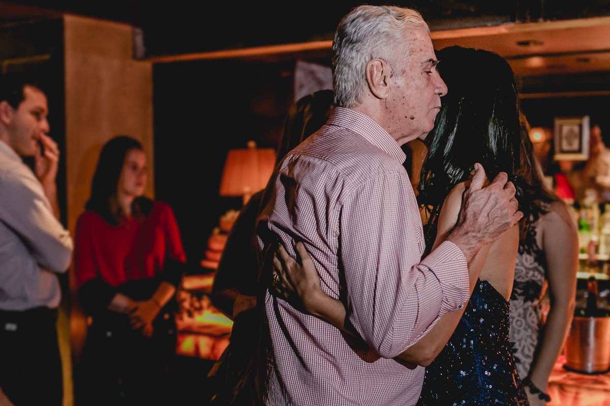 Clarissa recebendo um abraço e beijo do seu pai no começo da festa