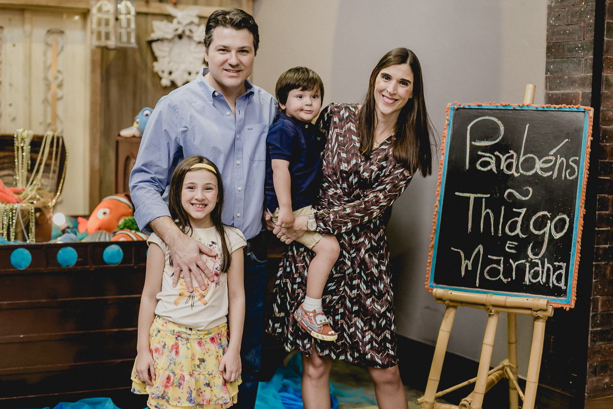 retrato em familia na frente da mesa do bolo
