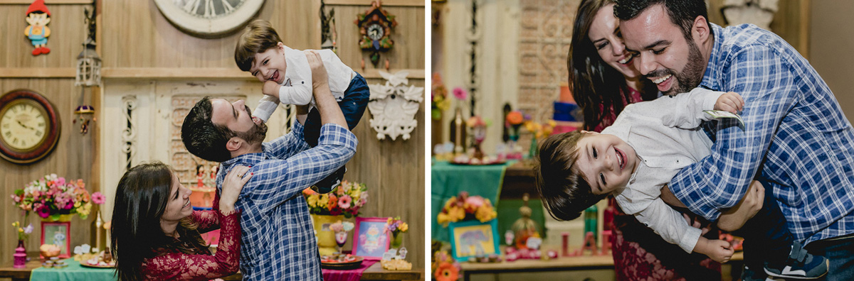 brincando com os pais na frente da mesa do bolo