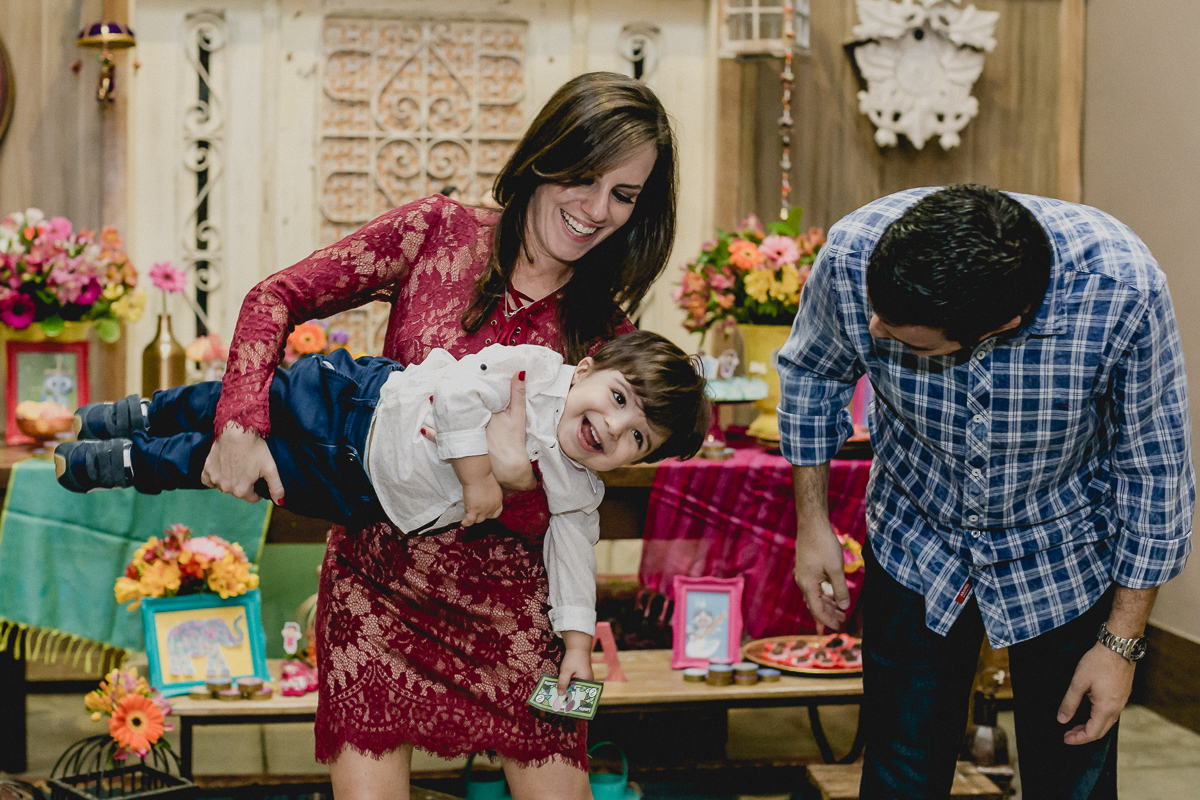 brincando com os pais na frente da mesa do bolo
