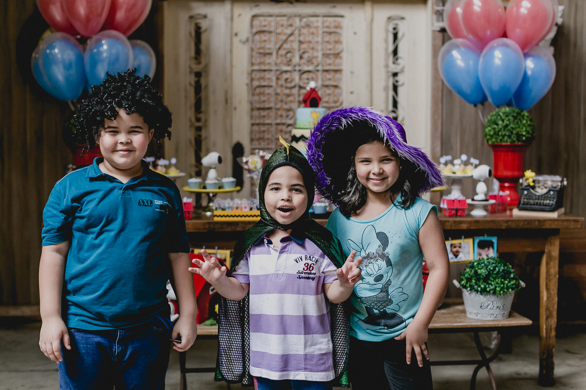 convidados fantasiados na frente da mesa do bolo