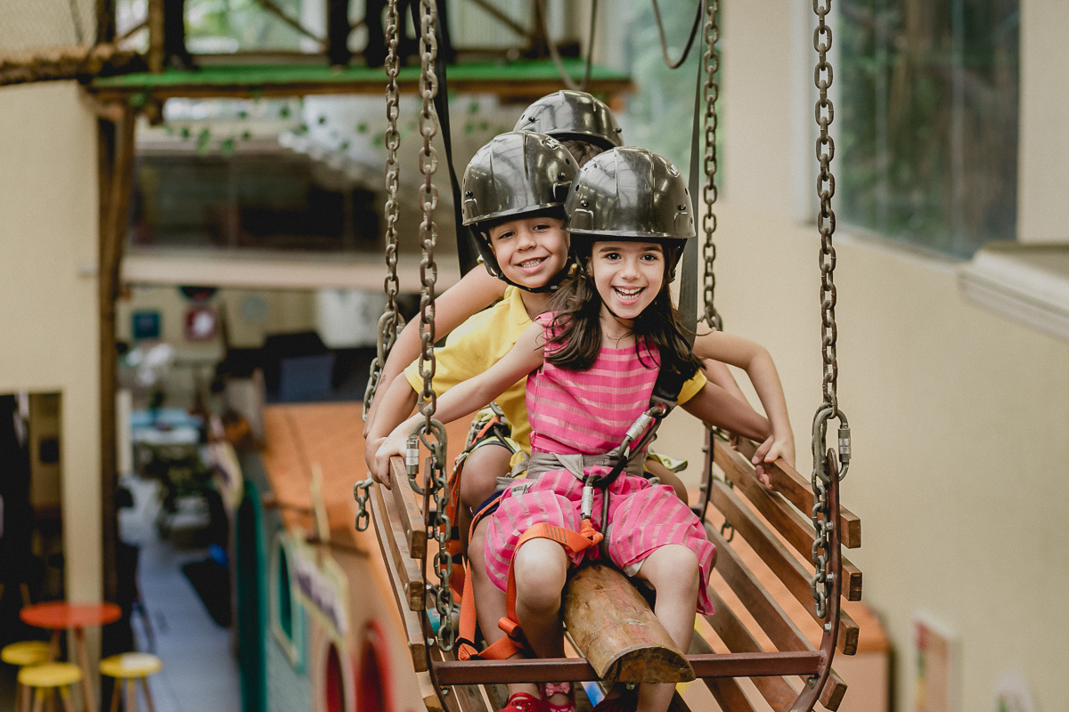 crianças atravessando a tirolesa no carrinho