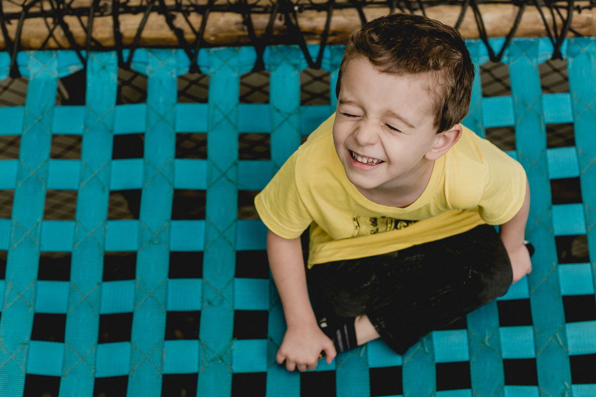 menino de olhos fechados na ponte azul