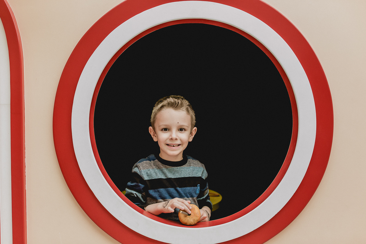 criança na janela vermelha