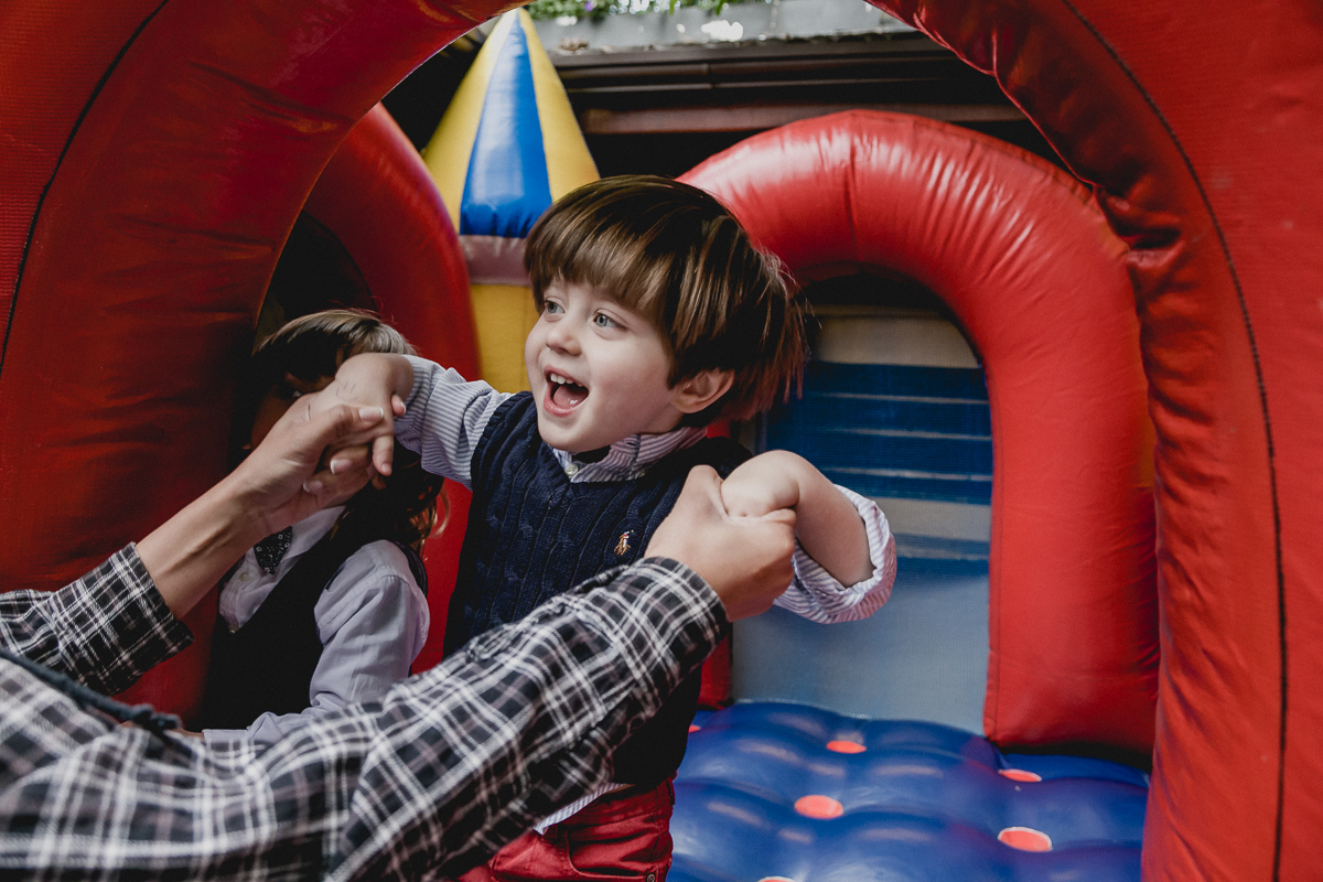 sorrindo muito e pulando no brinquedo inflavel