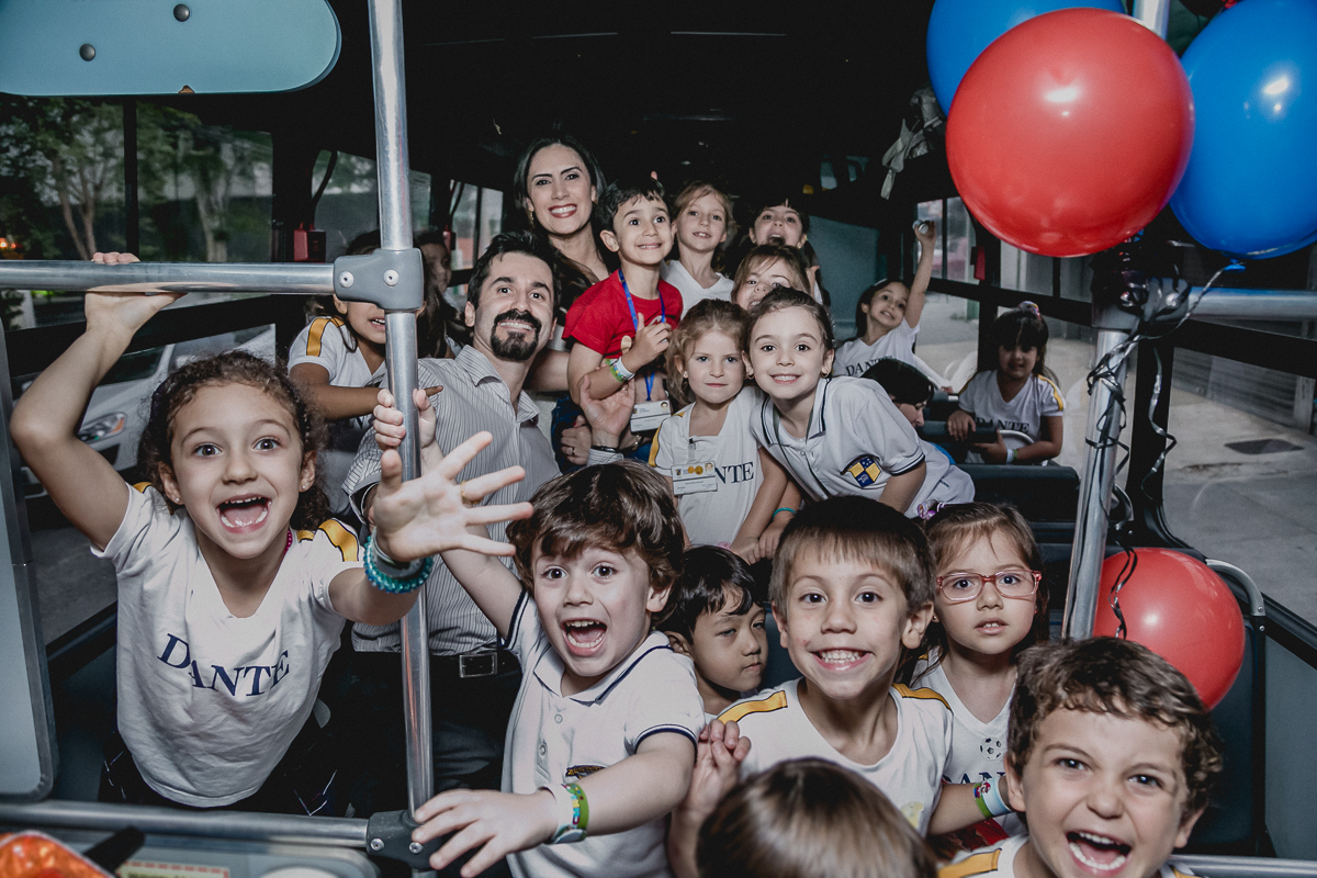 crianças dentro do onibus ansiosas para entrar na festa