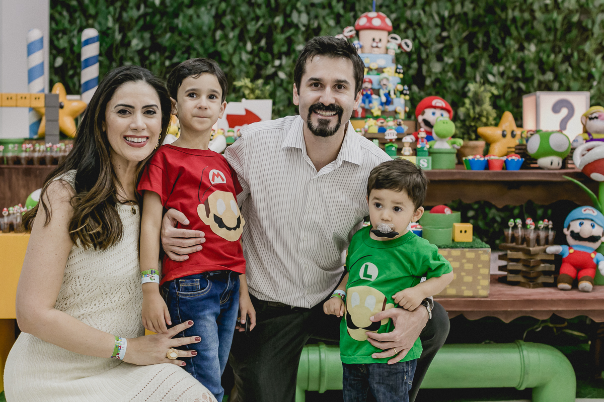 fotografia de familia na frente da mesa do bolo