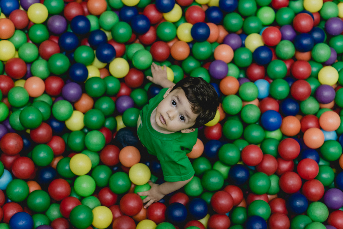 amiguinho sorrindo e se divertindo na piscina de bolinhas