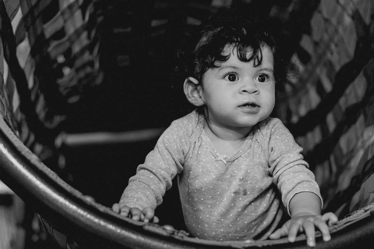 foto em preto e branco da lia brincando no tunel do brinquedao