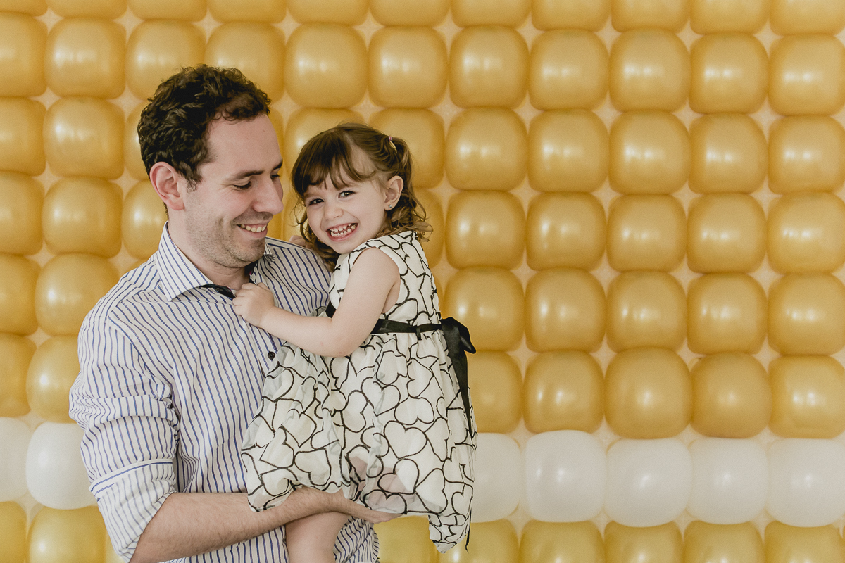 Laura e papai se divertindo na mesa do bolo