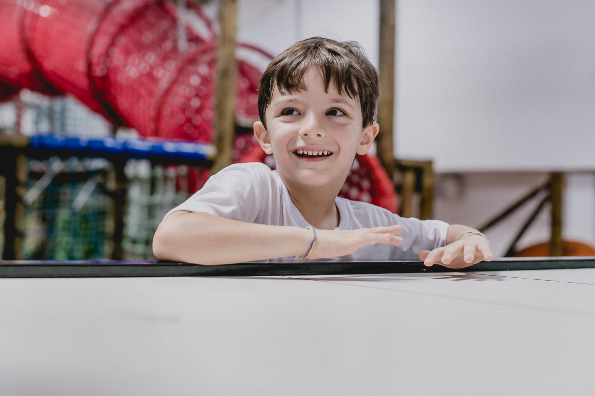 se divertindo no brinquedo de marcar gols