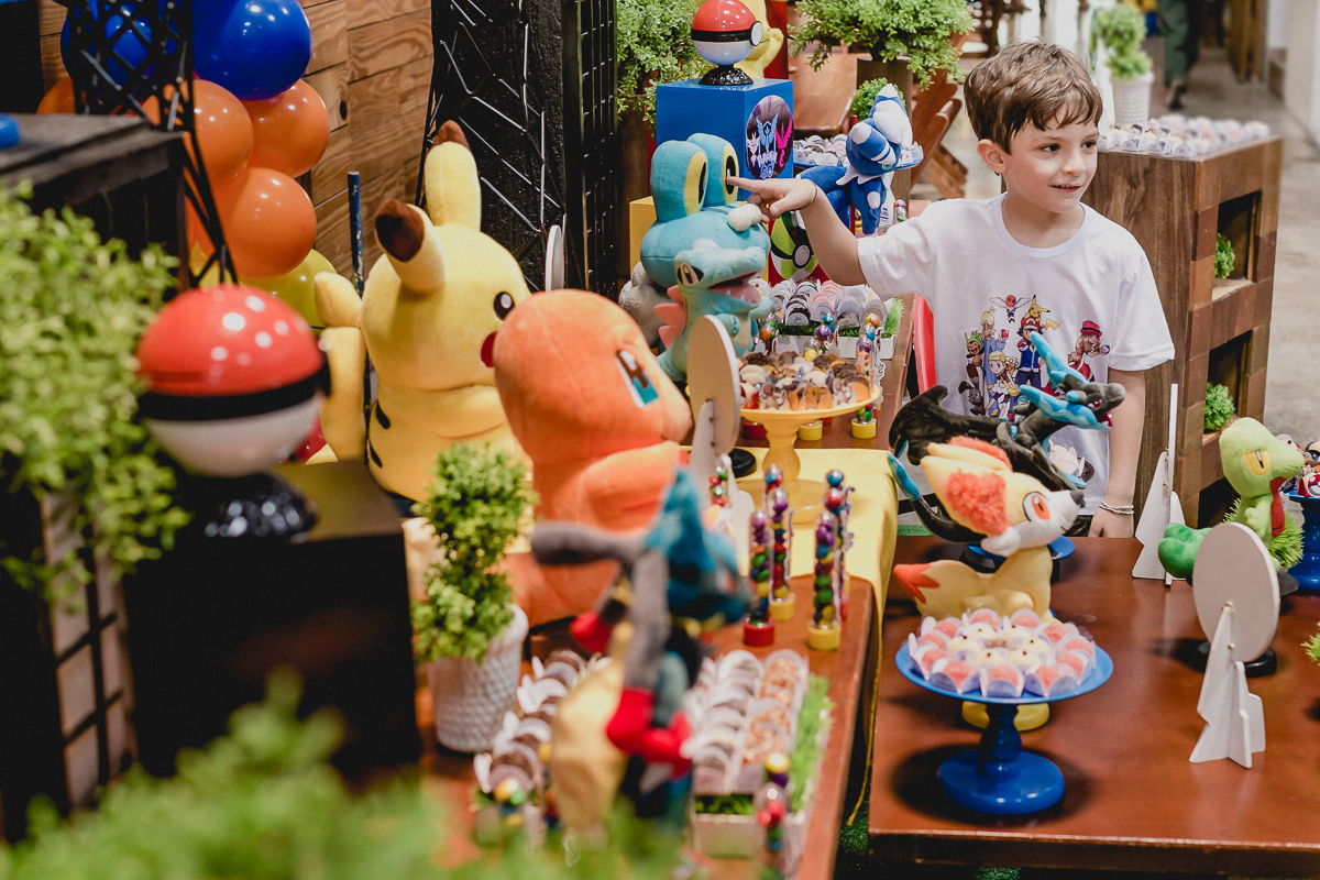 Pedro olhando a decoração da mesa do Pokemon