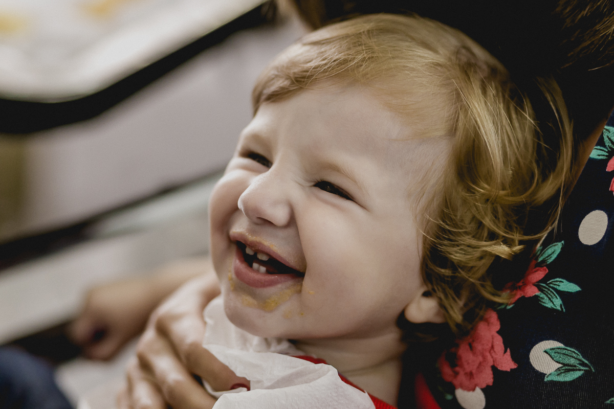 Matheus sorrindo com a boquinha suja de comida