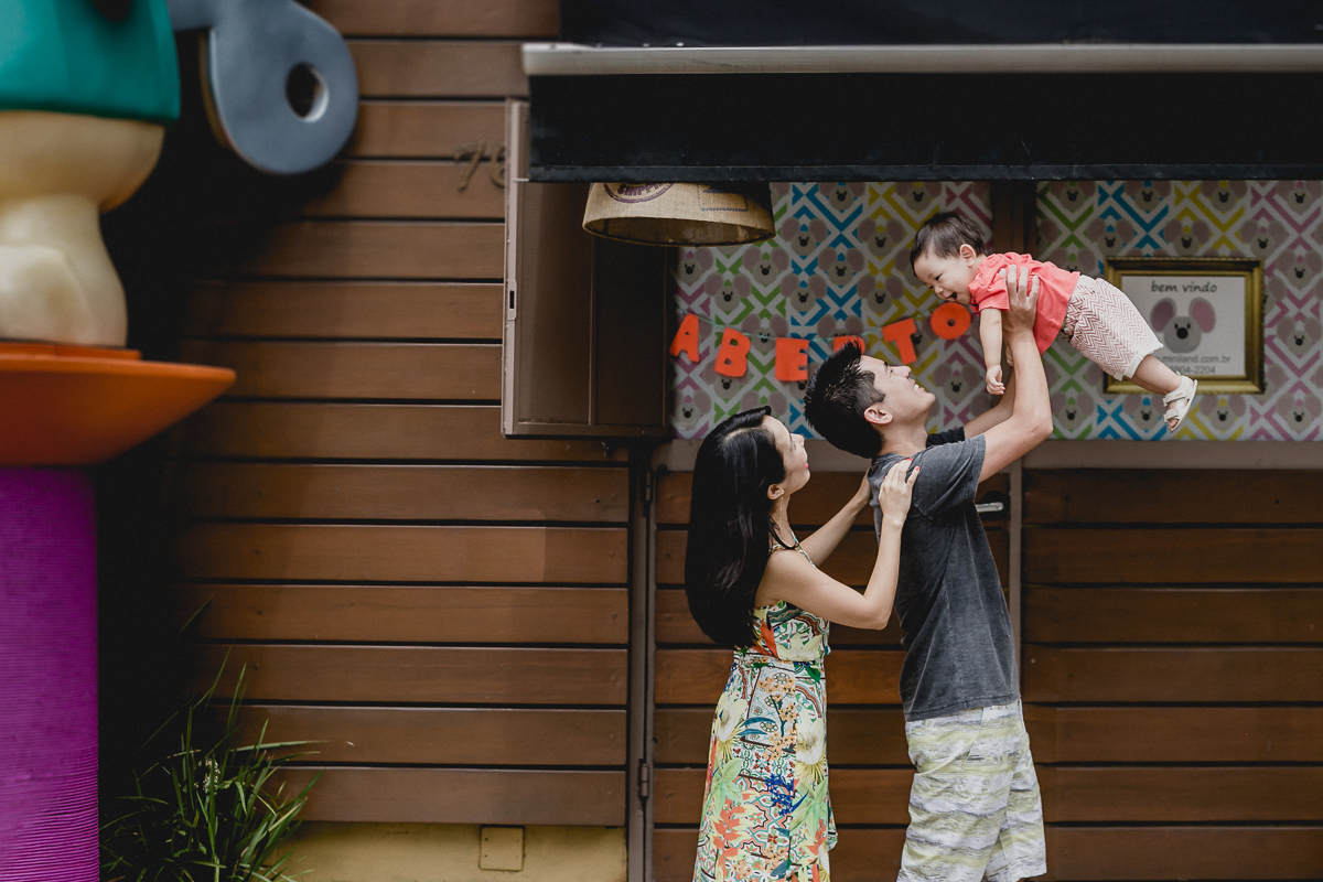 Caio brincando de aviãozinho com os pais