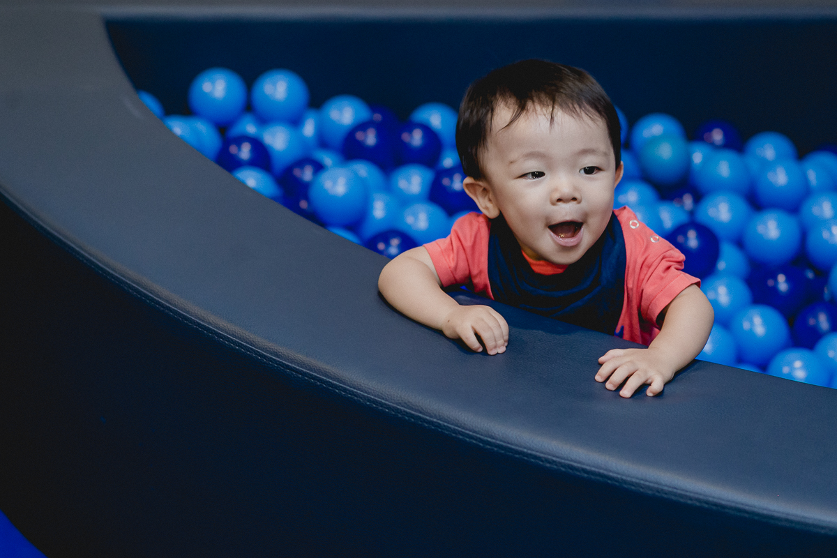 sorrindo e se divertindo na piscina de bolinhas