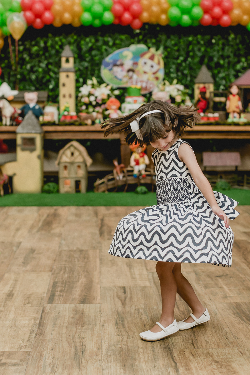 se divertindo e na frente da mesa do bolo