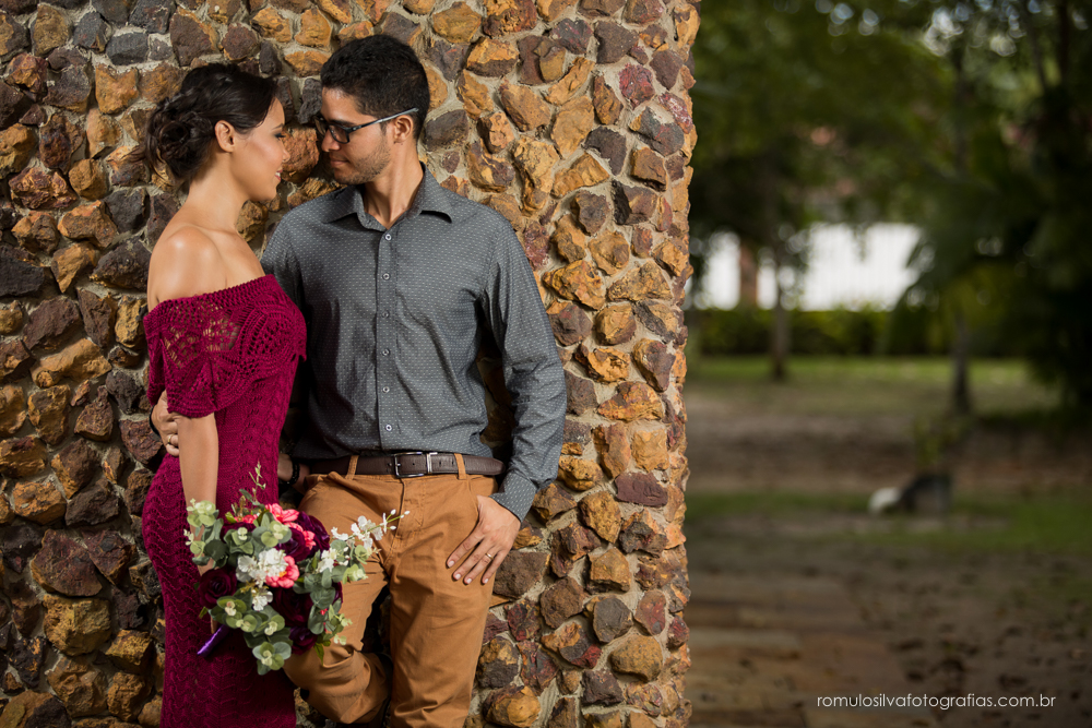 casal de noivos, Dulci e Glaisson, apaixonados, em uma pose linda e romântica em uma parede de pedras e uma luz perfeita, no Chalé da Zuzu em Mosqueiro - PA