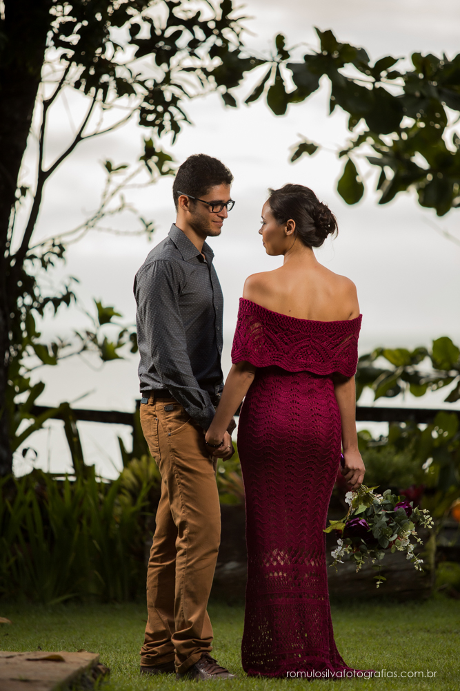 casal de noivos, Dulci e Glaisson, apaixonados, em uma pose linda, romântica, com um bouque em flores artificiais em uma paisagem linda e na beira da praia, no Chalé da Zuzu em Mosqueiro - PA