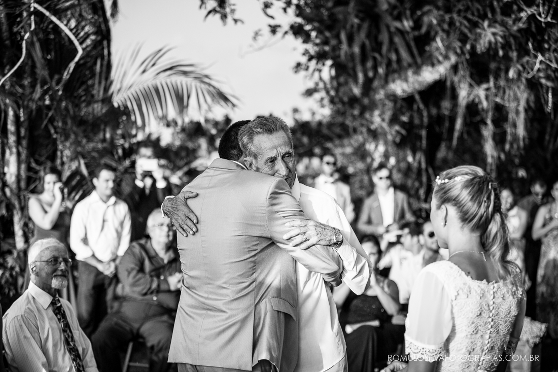 noivo abraçando o pai em cerimonia de casamento no fim de tarde 