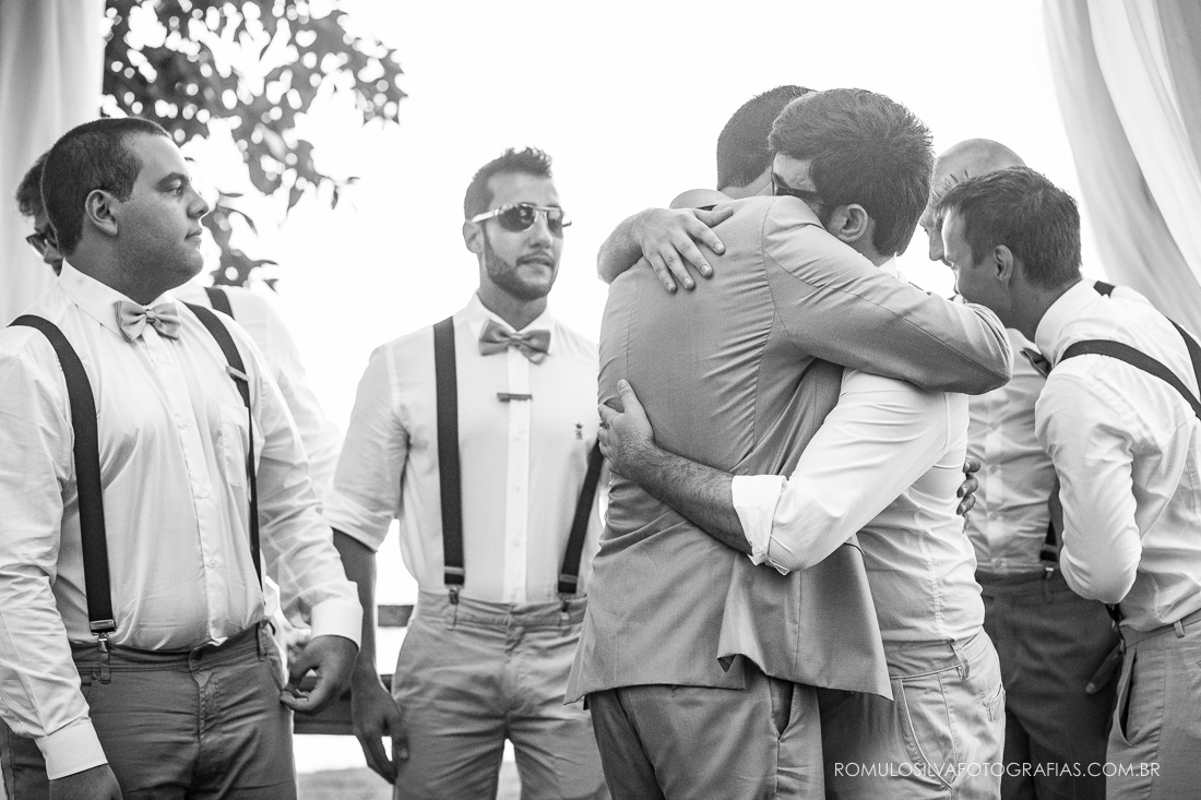 foto espontânea do noivo abraçando os padrinhos 