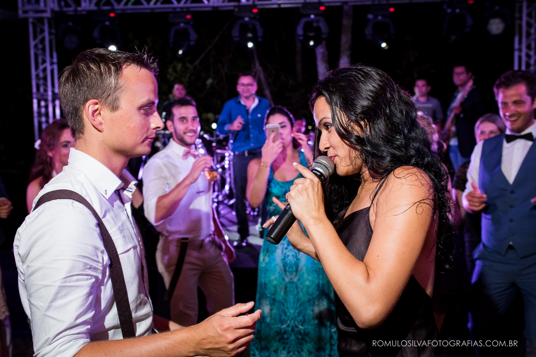 cantora no meio da pista cantando para convidado em festa de casamento