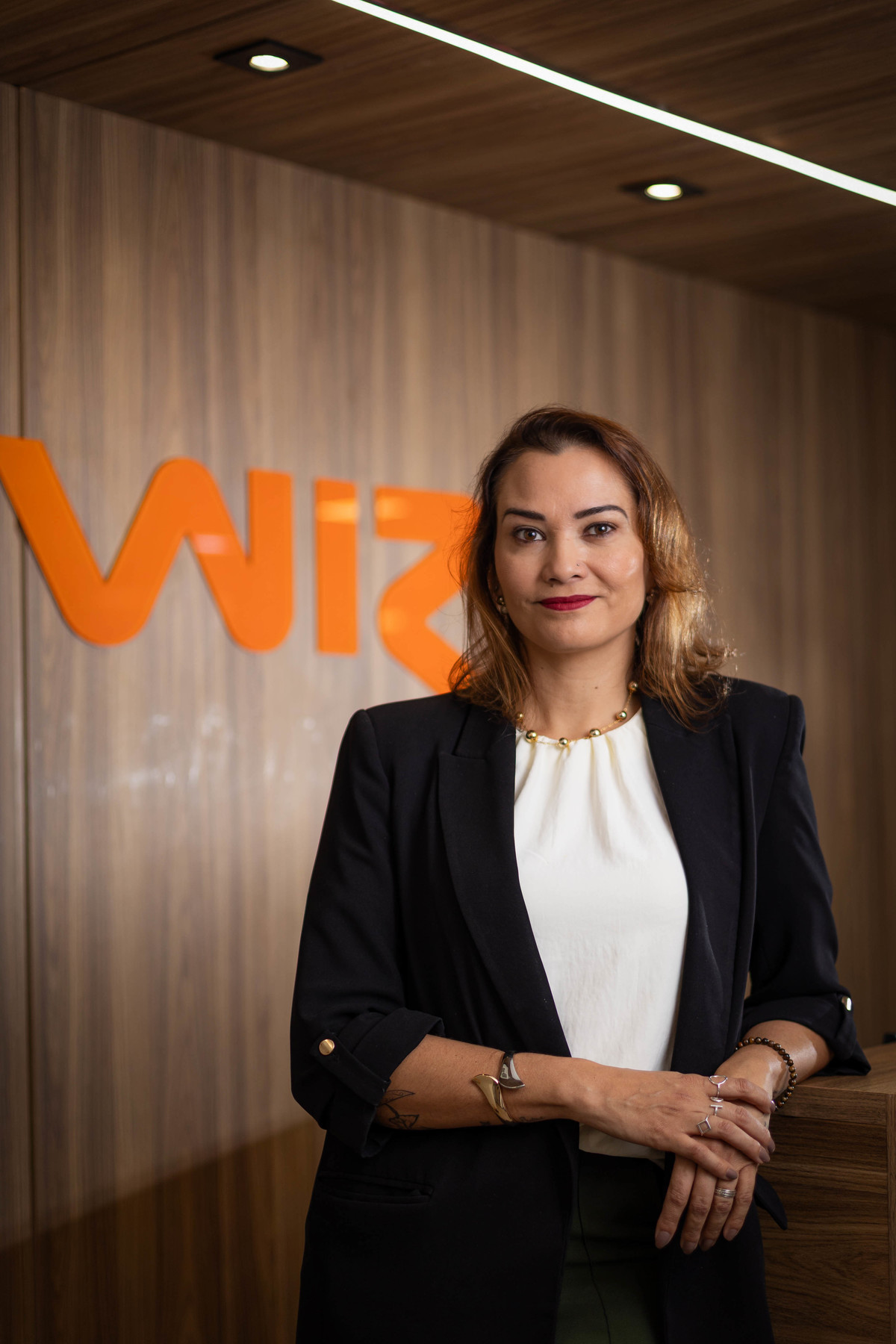 Retrato institucional de executiva da WIZ.co em Brasília, com a marca da empresa integrada ao cenário corporativo. Foto: Wenderson Araujo/Trilux