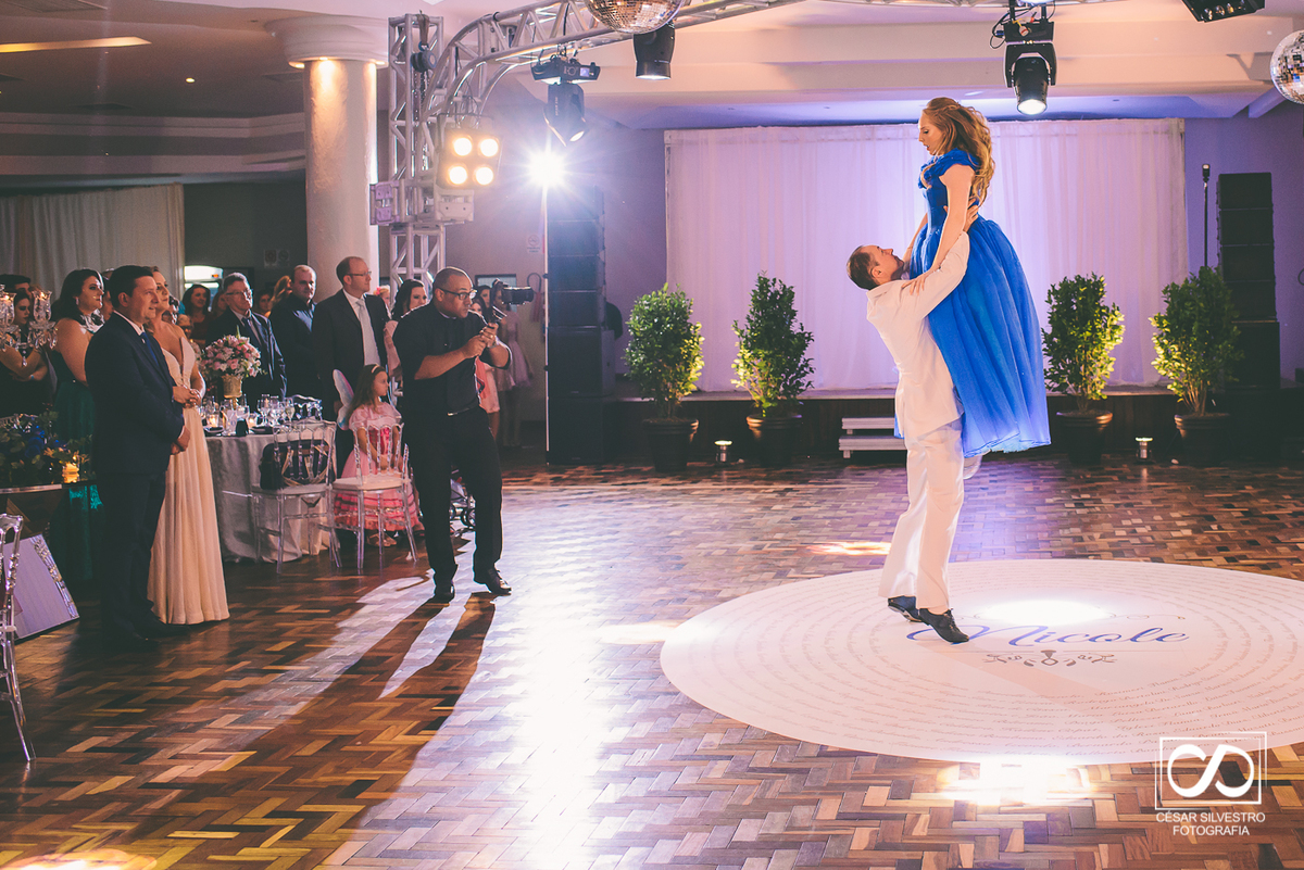 principe levantando a princesa no giro de sua valsa com os convidados ao lado esquerdo observando