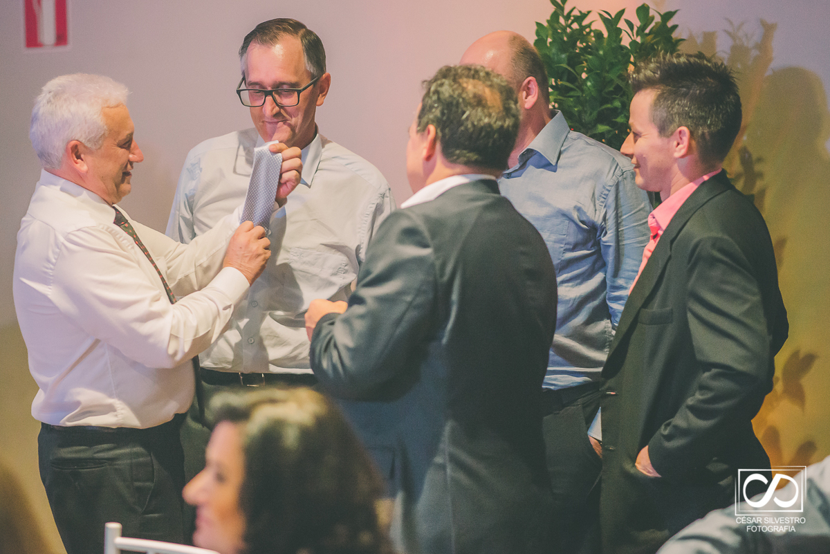 foto do noivo com os amigos ameaçando cortar a gravata na recepção no salão da todeschini  na serra gaucha com fotografia de cesar 