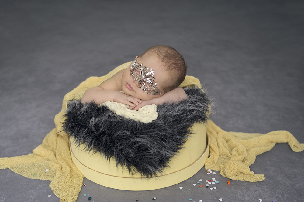 sessão fotográfica ensaio newborn menina recém nascido book fotográfico fotografia niteroi fotografo rio de janeiro amarelo com cinza são Gonçalo pose no baldinho de máscara de carnaval