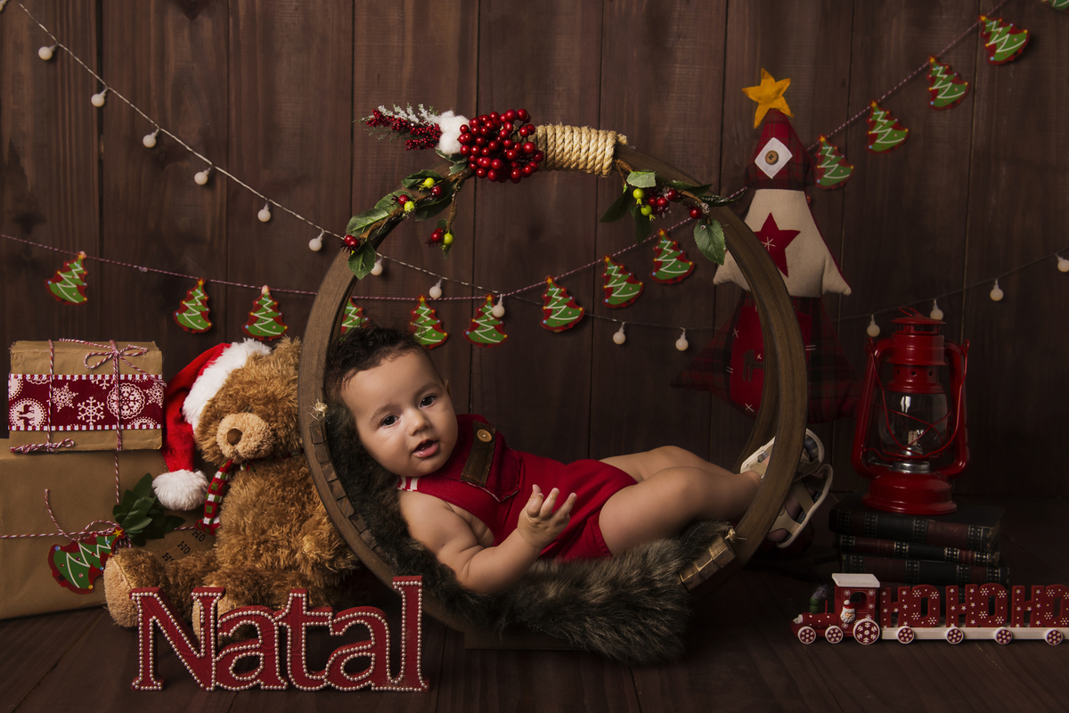 Ensaio fotográfico de Natal com roupas temáticas com crianças brincando no quartinho do Papai Noel com cama brinquedos arvore de natal presentes 