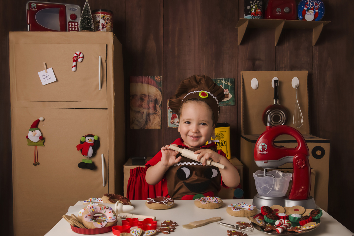
Ensaio fotográfico de Natal com roupas temáticas com crianças brincando de serem chefs de cozinha cenário temático de natal de cozinha com papai noel e comidas mini cozinha para crianças e bebês
