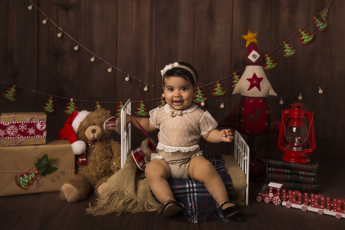Ensaio fotográfico de Natal com roupas temáticas com crianças brincando no quartinho do Papai Noel com cama brinquedos arvore de natal presentes 