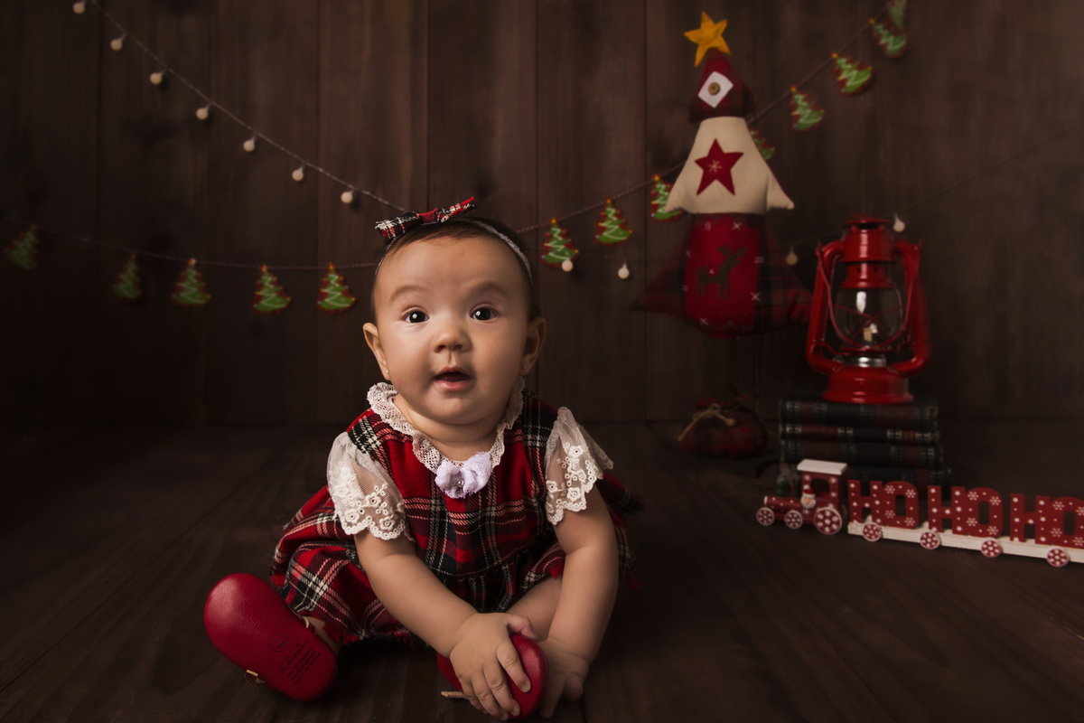 Ensaio fotográfico de Natal com roupas temáticas com crianças brincando no quartinho do Papai Noel com cama brinquedos arvore de natal presentes 