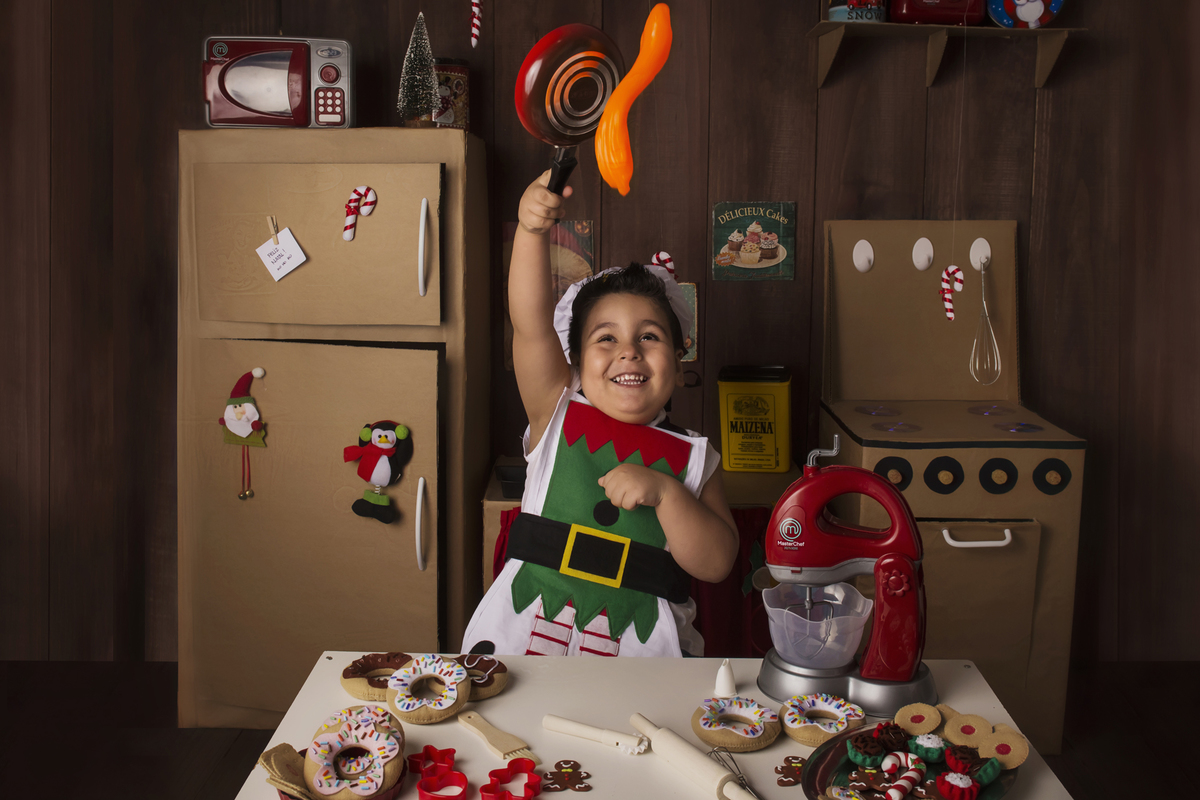 
Ensaio fotográfico de Natal com roupas temáticas com crianças brincando de serem chefs de cozinha cenário temático de natal de cozinha com papai noel e comidas mini cozinha para crianças e bebês
