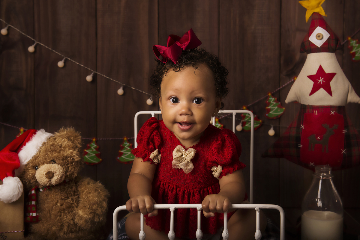 Ensaio fotográfico de Natal com roupas temáticas com crianças brincando no quartinho do Papai Noel com cama brinquedos arvore de natal presentes 