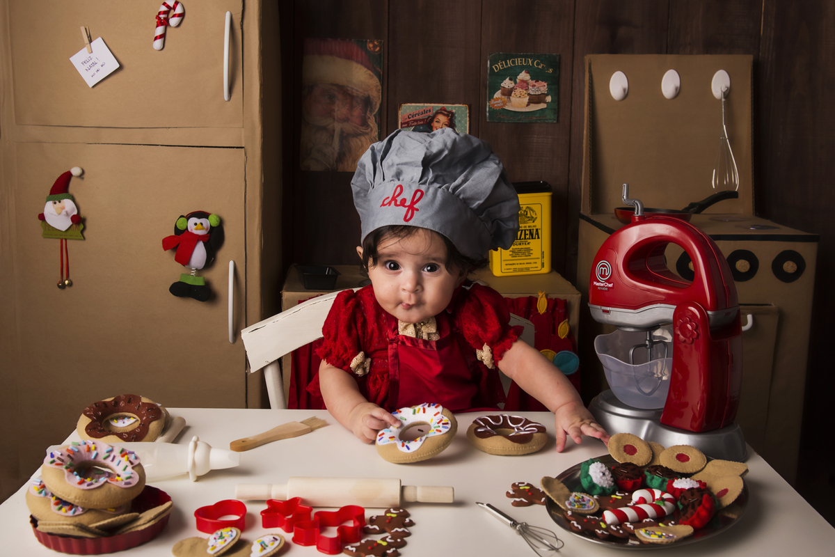 
Ensaio fotográfico de Natal com roupas temáticas com crianças brincando de serem chefs de cozinha cenário temático de natal de cozinha com papai noel e comidas mini cozinha para crianças e bebês
