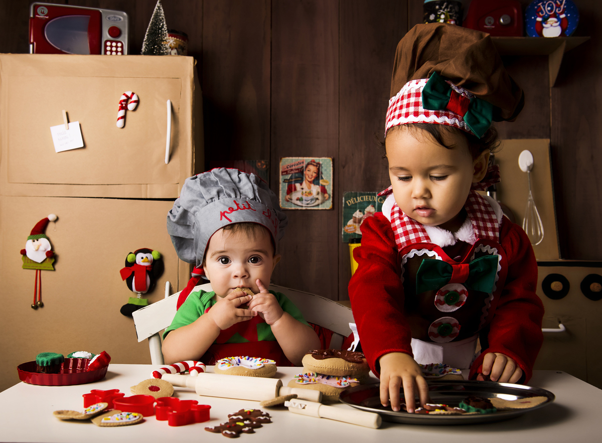 
Ensaio fotográfico de Natal com roupas temáticas com crianças brincando de serem chefs de cozinha cenário temático de natal de cozinha com papai noel e comidas mini cozinha para crianças e bebês
