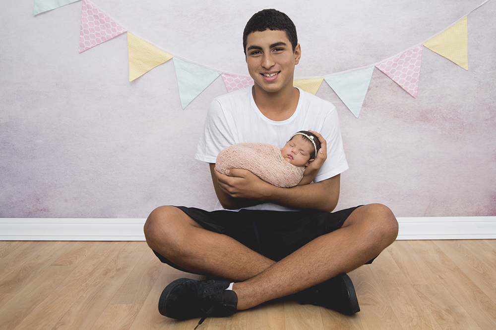 ensaio fotográfico newborn menina bebe recém nascida flores book fotográfico fotografia estúdio rio de janeiro niteroi são Gonçalo pose casulinho no colo do irmão