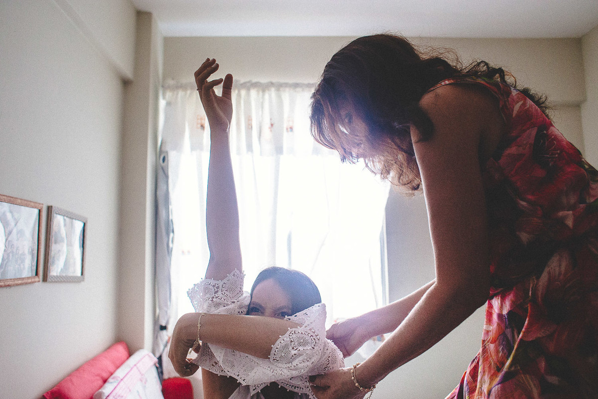 noiva recebendo ajuda da mãe para colocar o vestido. making of da noiva na cidade de recife pernambuco