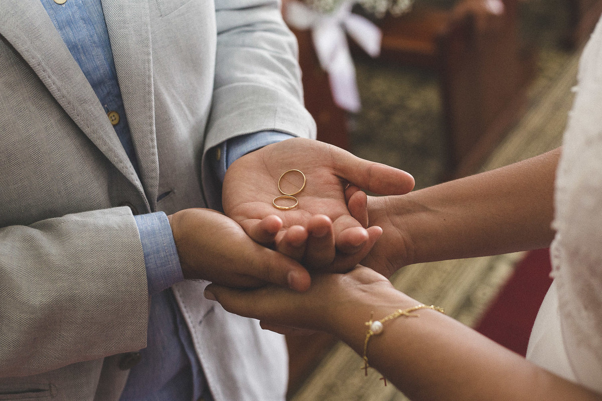 alianças nas mãos dos noivos durante a cerimônia de casamento