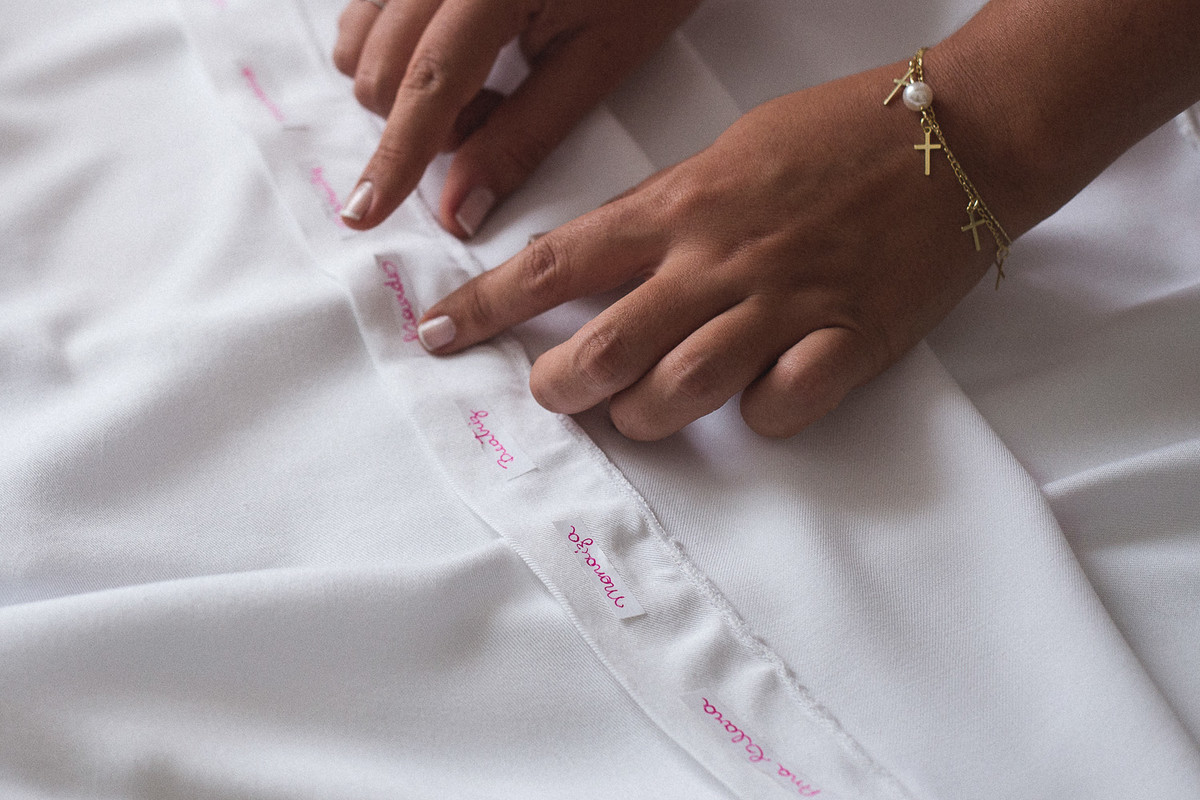 colando os nomes das solteiras na barra do vestido de noiva. making of da noiva na cidade de recife pernambuco