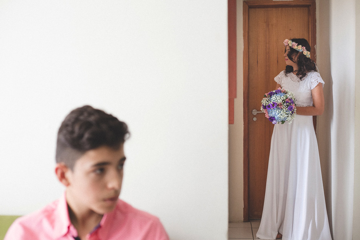 familiar da noiva em primeiro plano desfocado esperando sentando no sofá e noiva pronta em segundo plano.