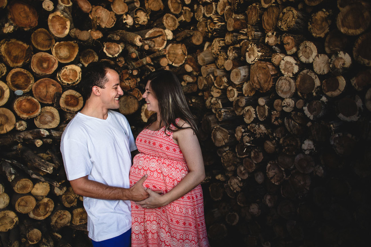 casal se olhando, mulher grávida e marido pegando na barriga.