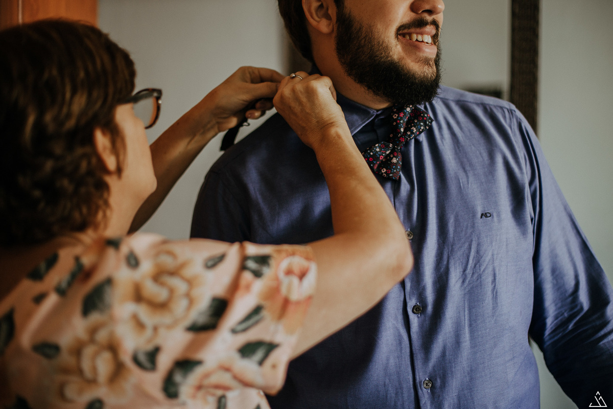 making of do noivo. fotógrafo de casamento em recife. mãe colocando gravata no noivo.