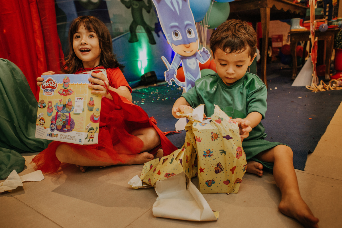 Jessica Mendes fotografia. Fotos da festa de aniversário infantil de 3 e 5 anos de idade de Ana e Fernando. Fotos de criança abrindo os presentes na festa de aniversário.